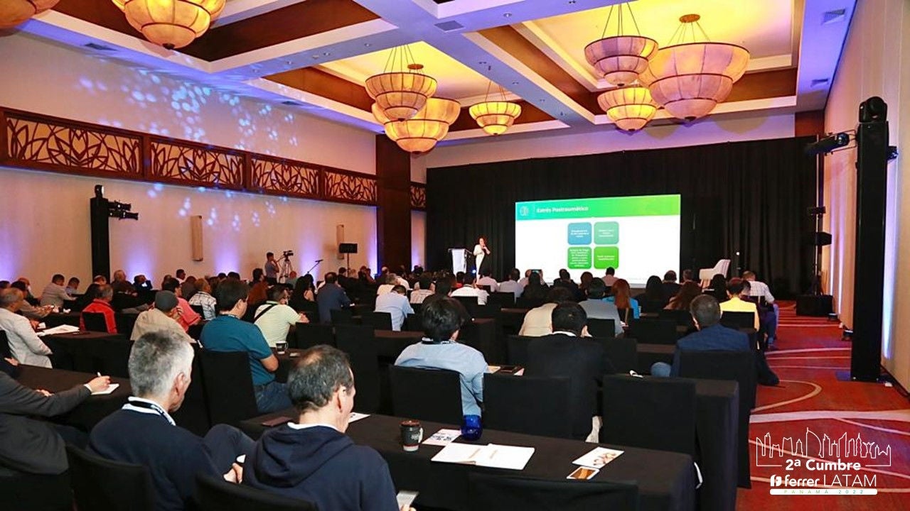 A large audience attends a corporate presentation during the 2nd Ferrer LATAM Summit in an illuminated conference room.