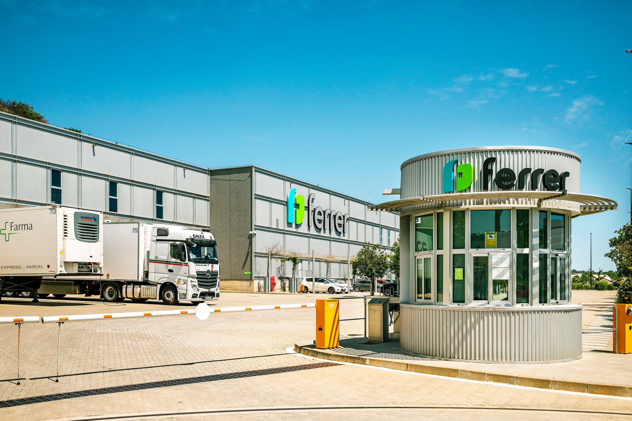 Centre logístic de Ferrer amb accés principal, camió de transport i garita de seguretat amb el logotip de la companyia.