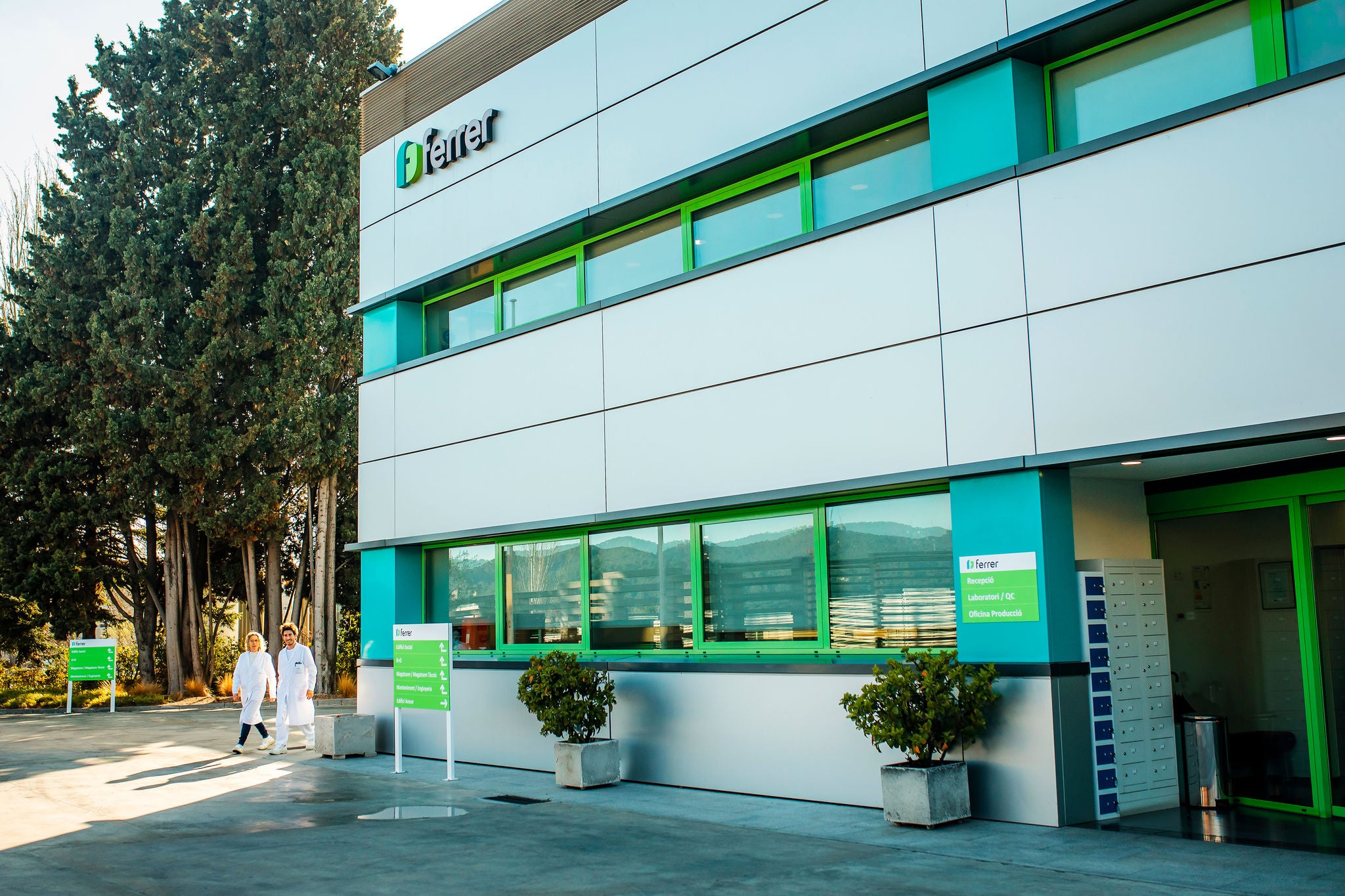 Instal·lacions de Ferrer a Sant Cugat, amb façana corporativa, accessos senyalitzats i professionals caminant al costat de l'edifici.
