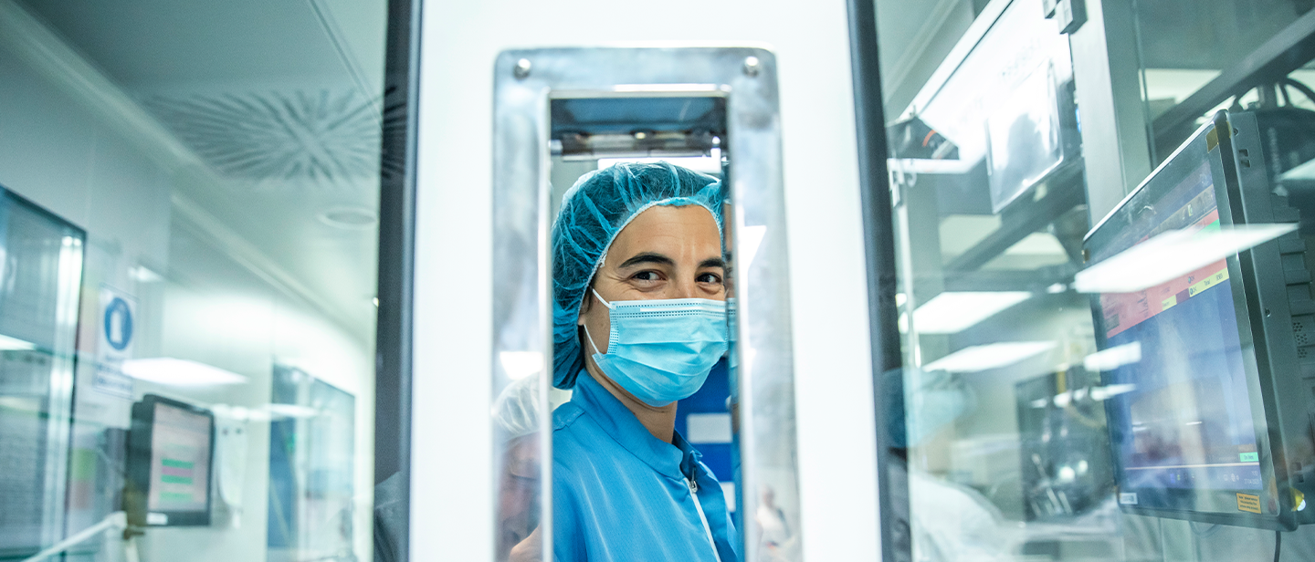A specialized worker wearing a mask and blue clothing in an industrial production plant of the Ferrer company.