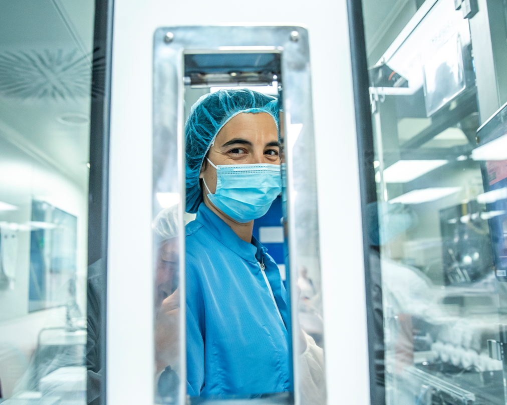 A specialized worker wearing a mask and blue clothing in an industrial production plant of the Ferrer company.