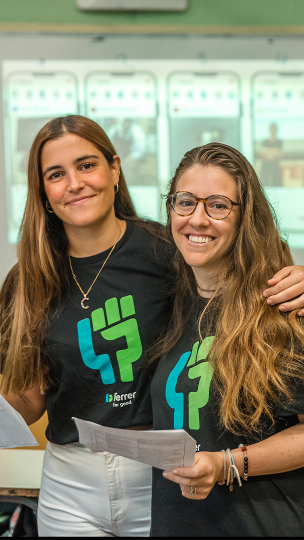 Two people from Ferrer's team smile at the camera wearing corporate T-shirts during an internal company activity.