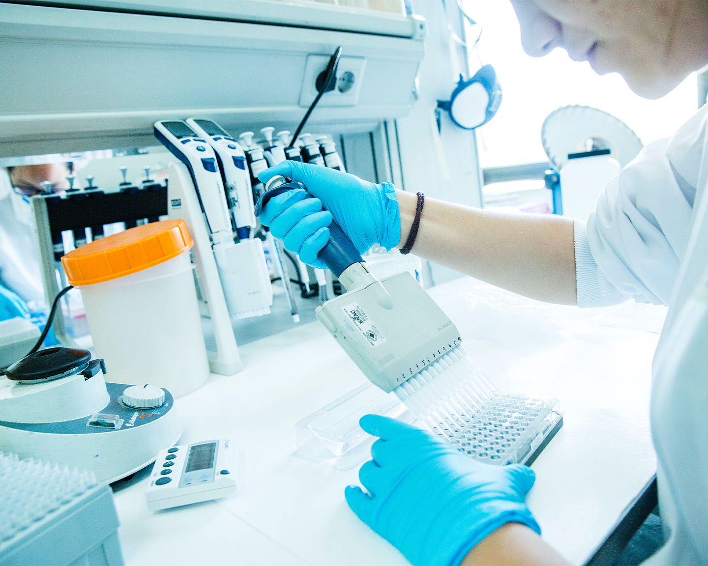 Investigadora de Grupo Ferrer realizando tareas de I+D con una micropipeta en el laboratorio farmacéutico.