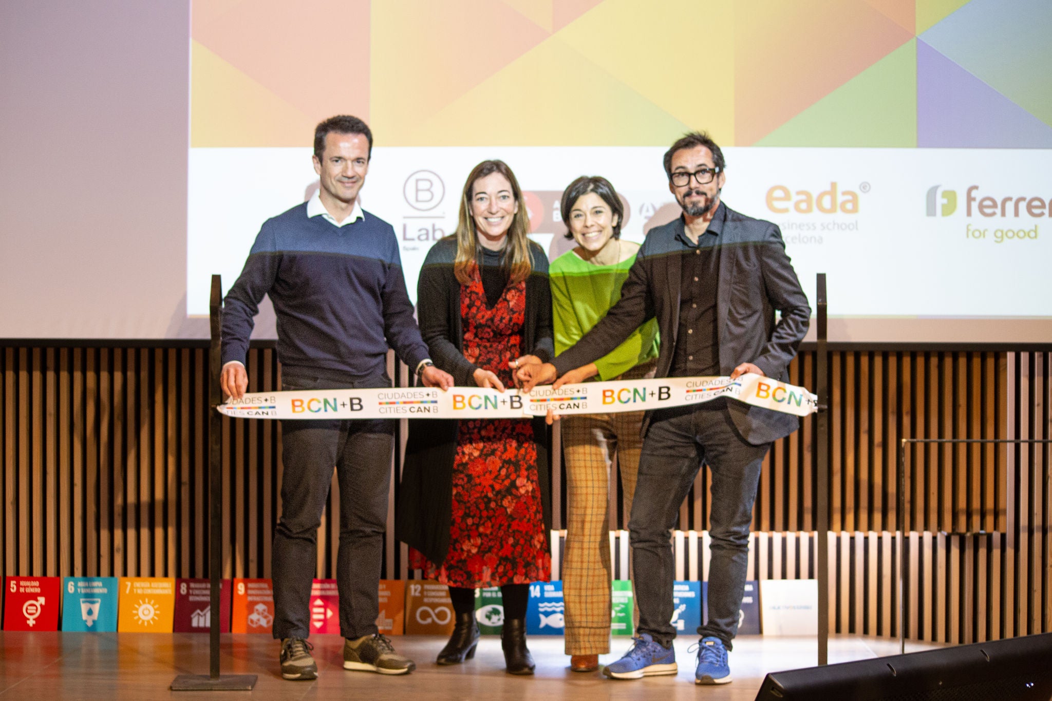 Four people cutting an inaugural ribbon with BCN and Ferrer logos, in front of a screen with corporate brands.