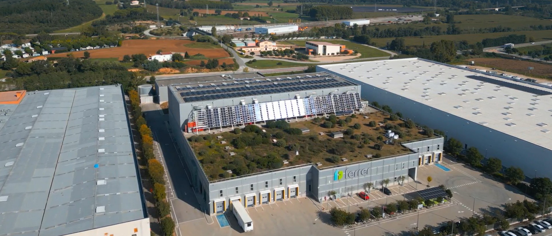 Vista aèria del Centre Logístic de Ferrer amb una instal·lació fotovoltaica a la coberta, en una notícia sobre la descarbonització i l'impuls d'energies renovables.