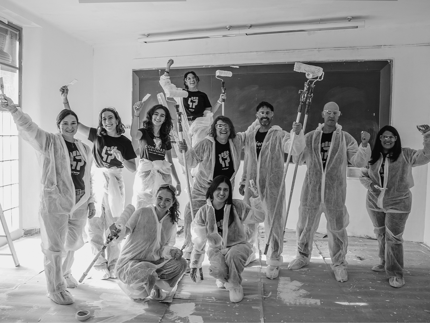 Equip de voluntaris de Grup Ferrer en una acció col·lectiva pintant una aula escolar durant una jornada de voluntariat.