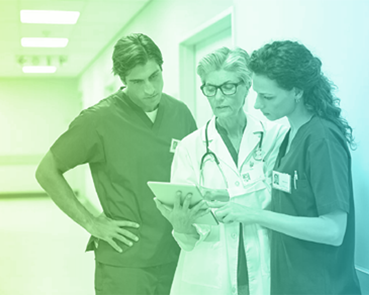 Healthcare professionals review information on a tablet in a hospital setting, collaborating in clinical decision-making.