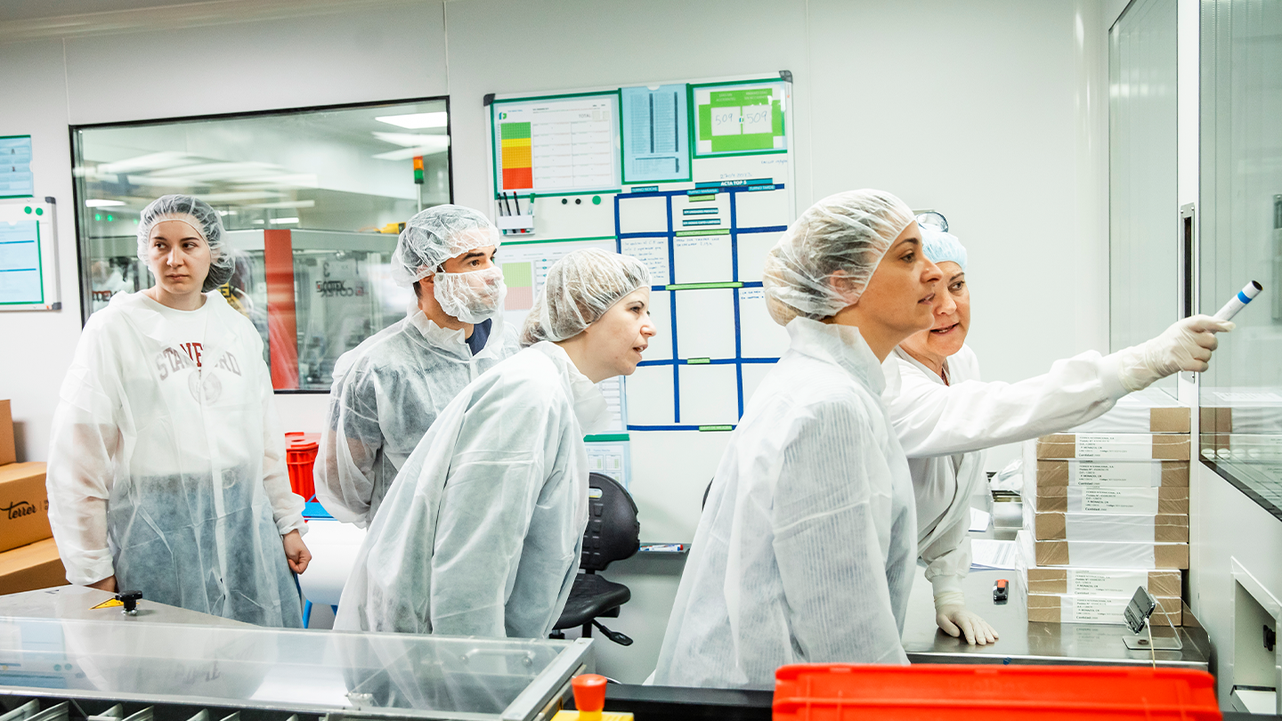 Team of operators in a pharmaceutical manufacturing clean room, leading the operational management of Ferrer's value chain.
