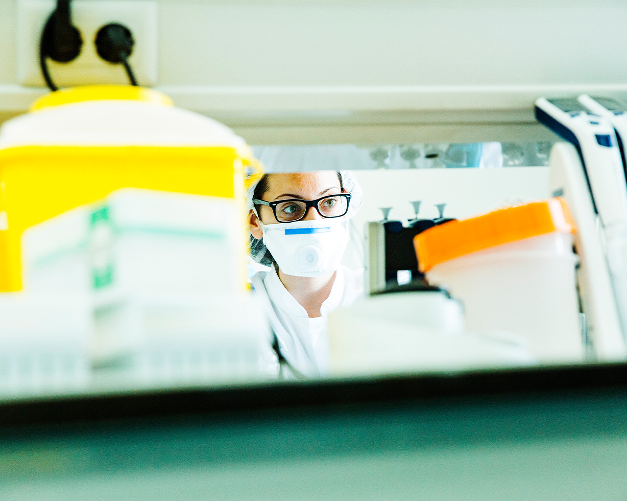 A researcher with a mask and glasses working in the laboratory for drug development at the company Ferrer.