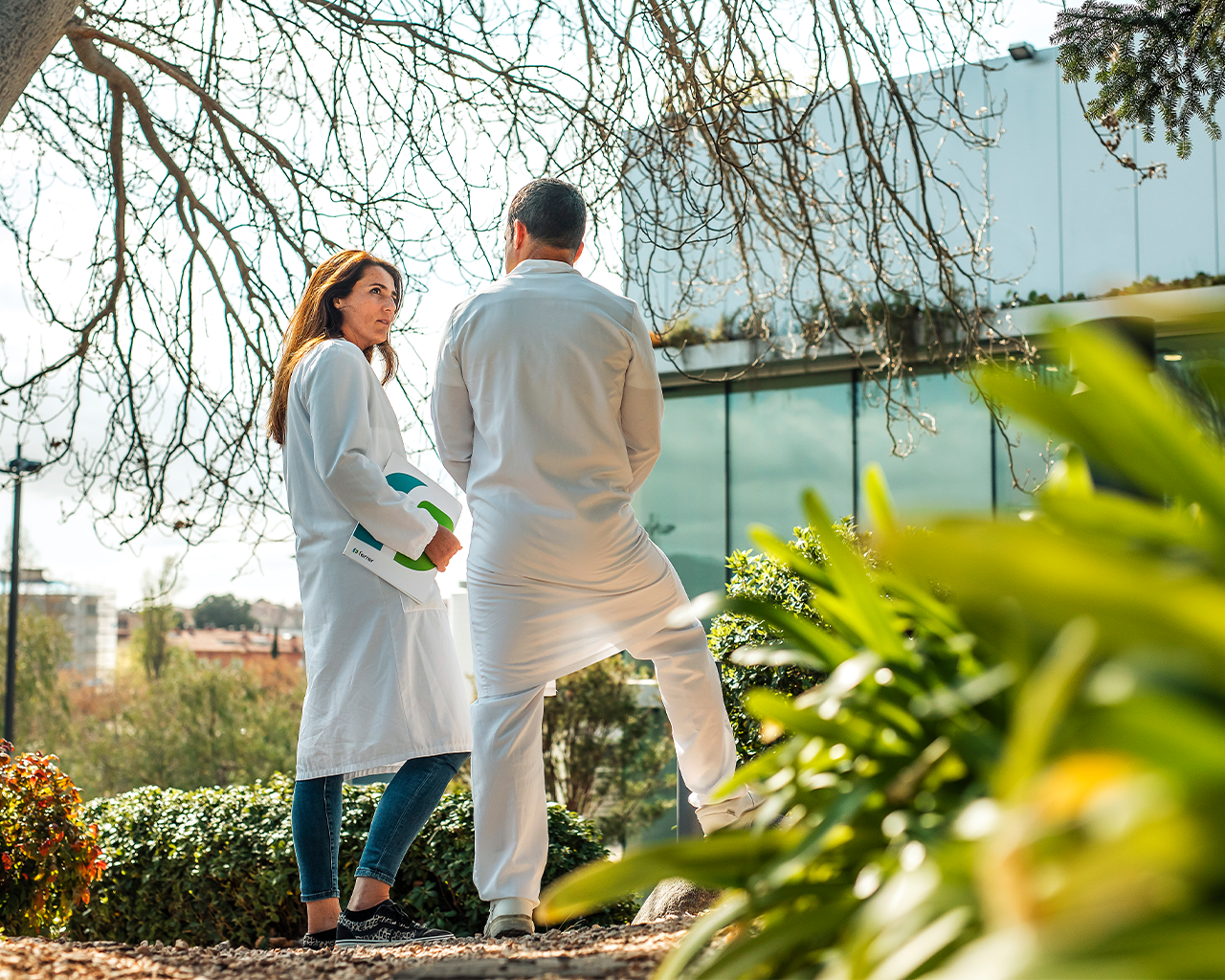 Two researchers talking in the outdoor areas of Grupo Ferrer's sustainable facilities.