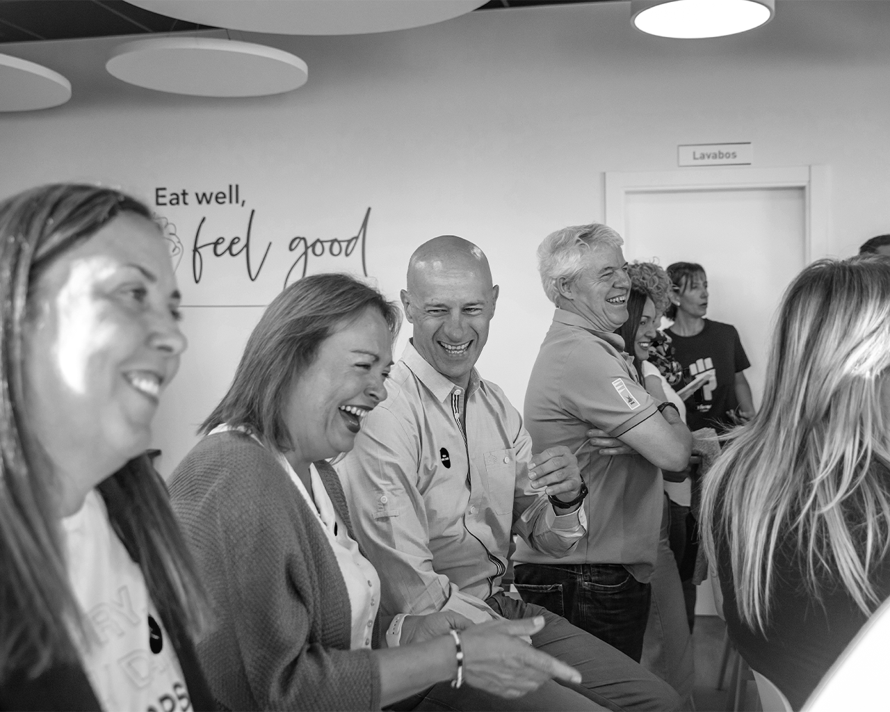 Empleados del grupo Ferrer sonriendo y compartiendo un momento distendido durante una actividad corporativa de salud y bienestar.