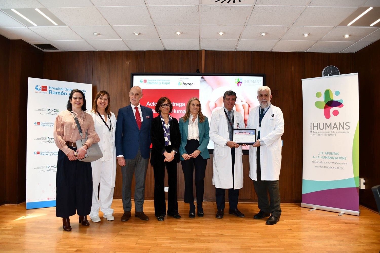 Grupo de profesionales médicos e institucionales posando juntos durante la entrega de un reconocimiento en el Hospital Ramón y Cajal.