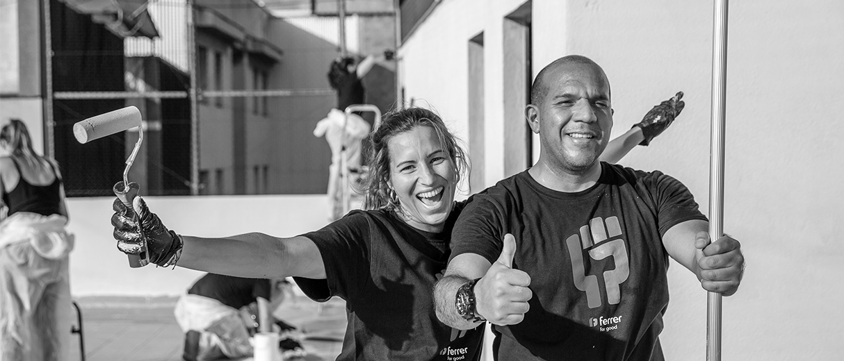 Voluntaris amb samarretes de "Ferrer for good" col·laborant en la rehabilitació d'un espai durant una acció social de l'empresa.