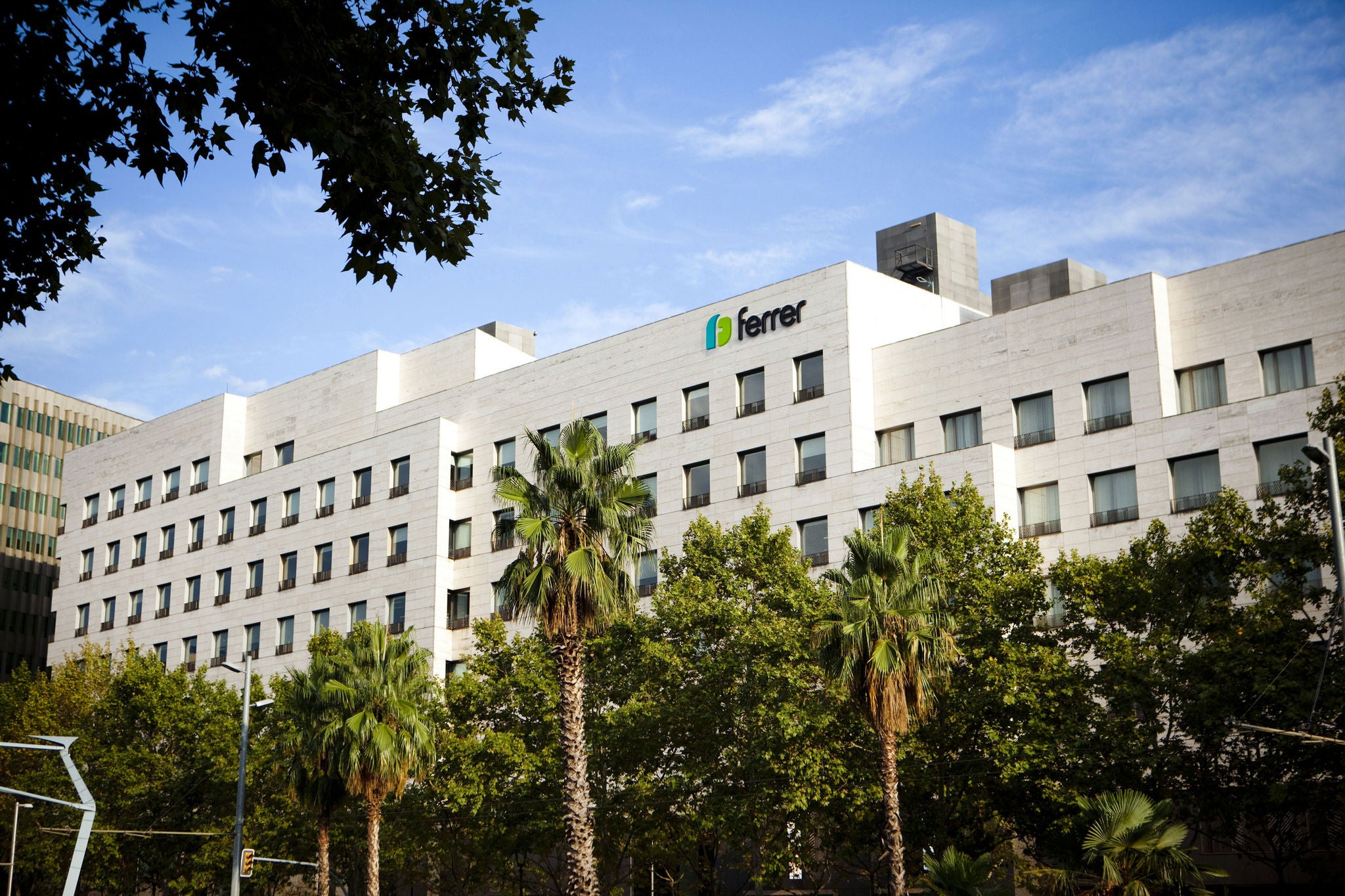 Edifici de Ferrer a Barcelona, amb el logotip de la companyia a la façana i zones verdes en primer pla.