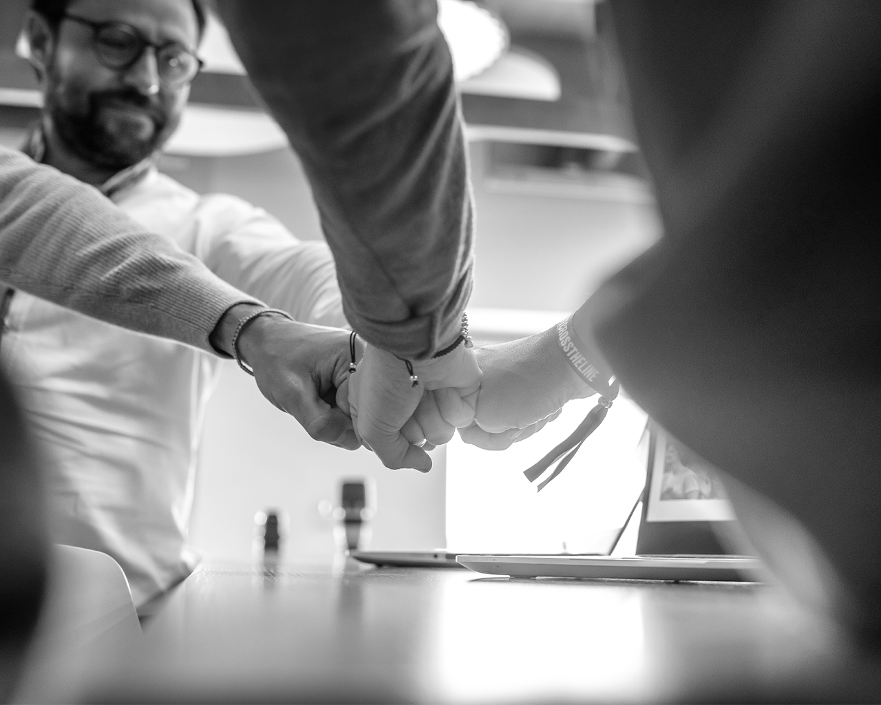 Members of Grupo Ferrer's management team joining fists in a corporate leadership and strategy meeting.