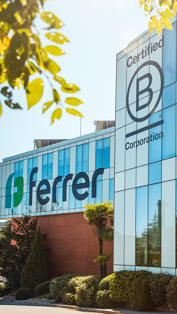 Façana exterior de l' edifici corporatiu de Ferrer amb el logotip de l' empresa i el segell de certificació B Corporation.